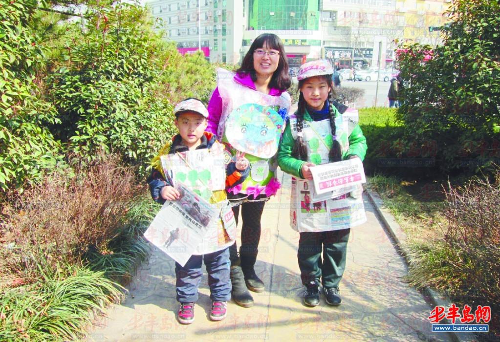 李潇奕右穿着用报纸做的衣服，和妈妈弟弟一起上街义卖半岛都市报。